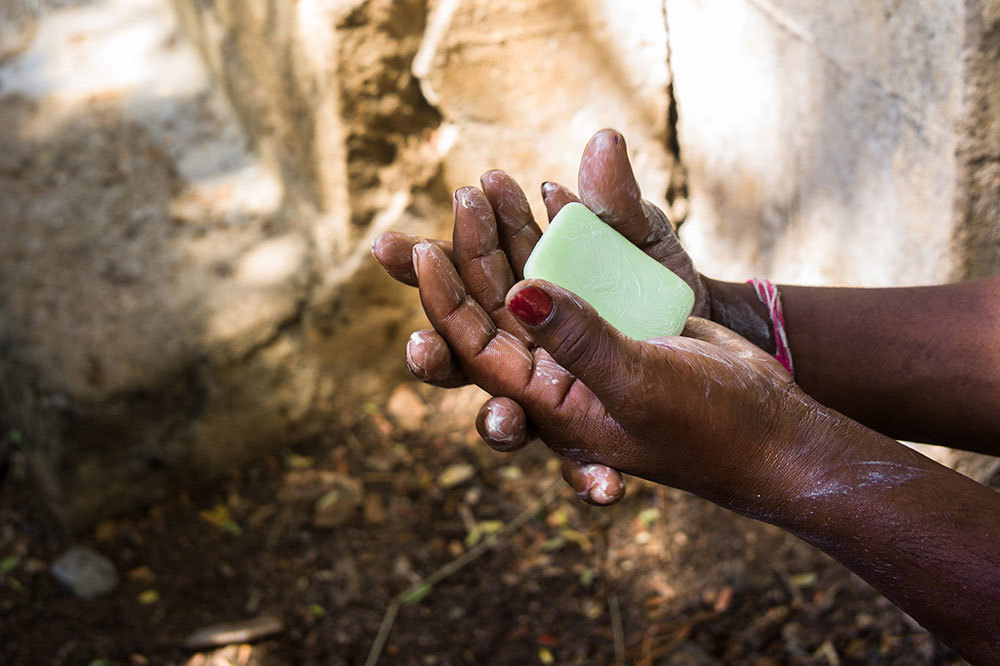 A teacher instructs children in rural India on how to use soap to clean