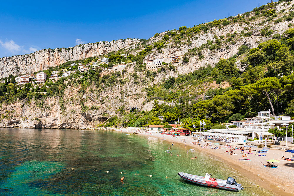 Beach with turquoise waters surrounded by rocky cliff faces