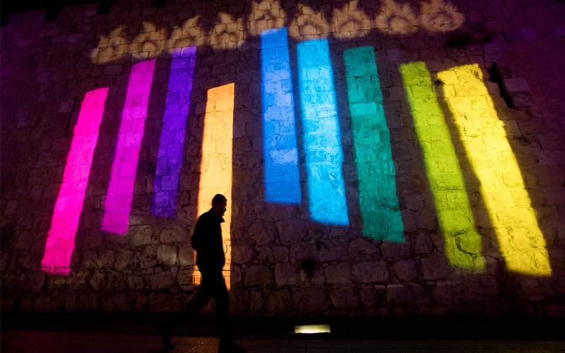 On the walls of Jerusalem's Old City, a colorful menorah lights up the night during Hanukkah. 