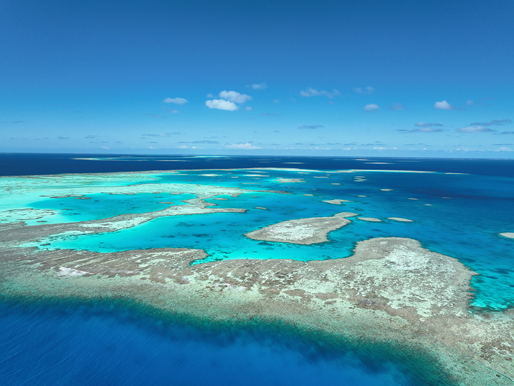 An aerial view of an island around bright blue seas