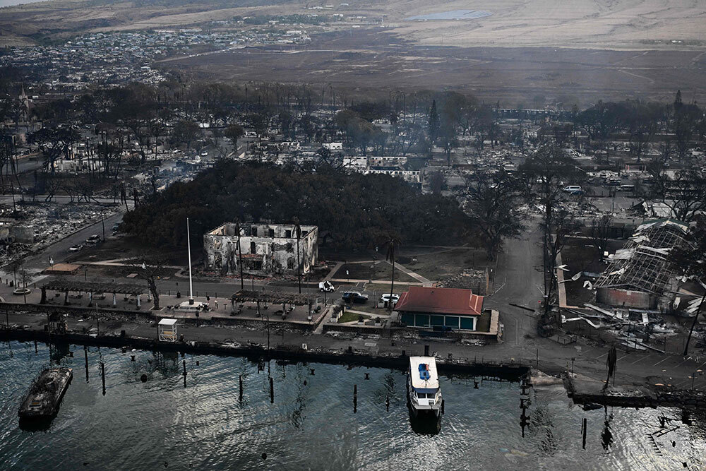 An aerial view shows the scorched historic banyan tree along with destroyed homes, boats, and buildings burned to the ground.