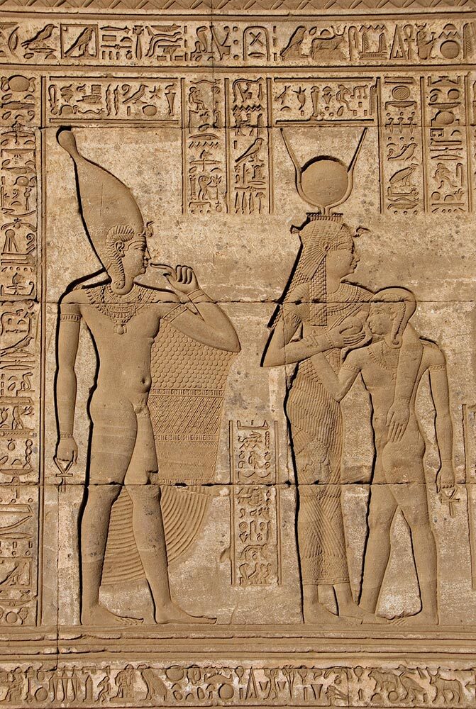 A sandstone hieroglpyh dating to 2250 B.C. shows the goddess Isis, her son, and the god Hathor (far left).