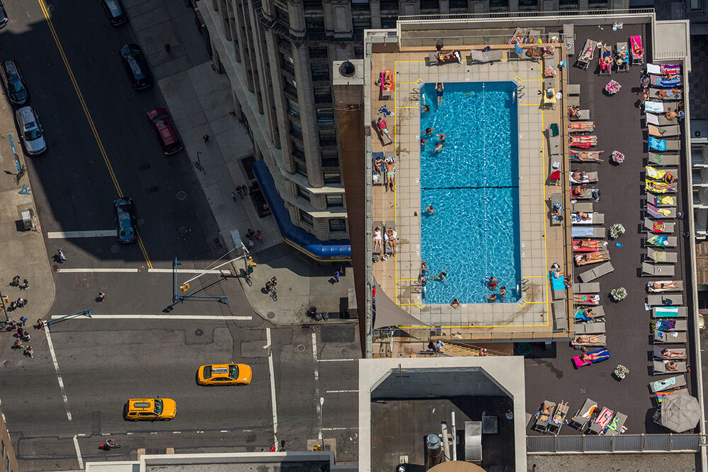 In the summer of 2014, New Yorkers escape the urban heat island in a rooftop pool in Greenwich Village. The city has one million buildings and an ambitious plan to increase energy efficiency by retrofitting the largest ones.