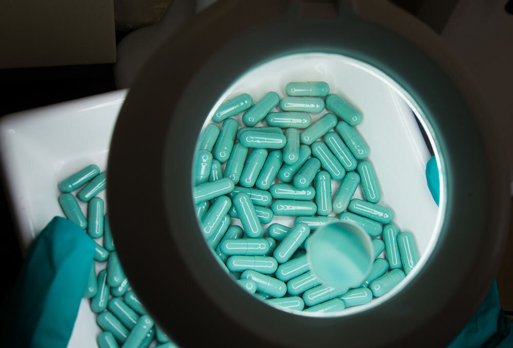 An employee inspects medications produced at STADA Azneimittel AG in Bad Vilbel, Germany. STADA specializes in the production of generic and over-the-counter pharmaceuticals.