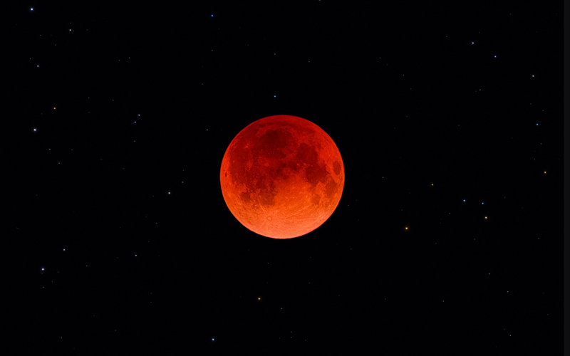 During a total lunar eclipse (one in 2022 seen here in Portugal), light is refracted through Earth's atmosphere, casting a fiery glow on the moon's surface. 