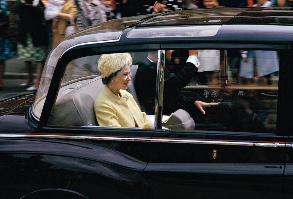The queen rides in the back of a black car