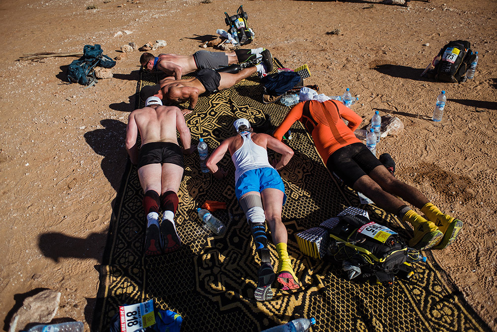 A group of athletes do push ups in the sand