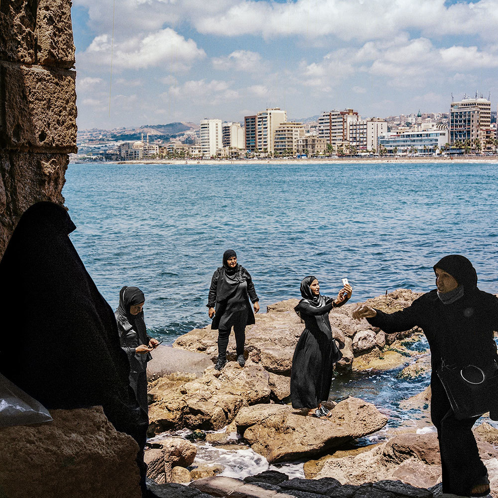 Women taking photographs at the ruins of an old Crusader fort on the coast of Lebanon