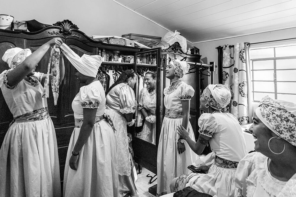 Women laugh and dress in preparation for a ceremony