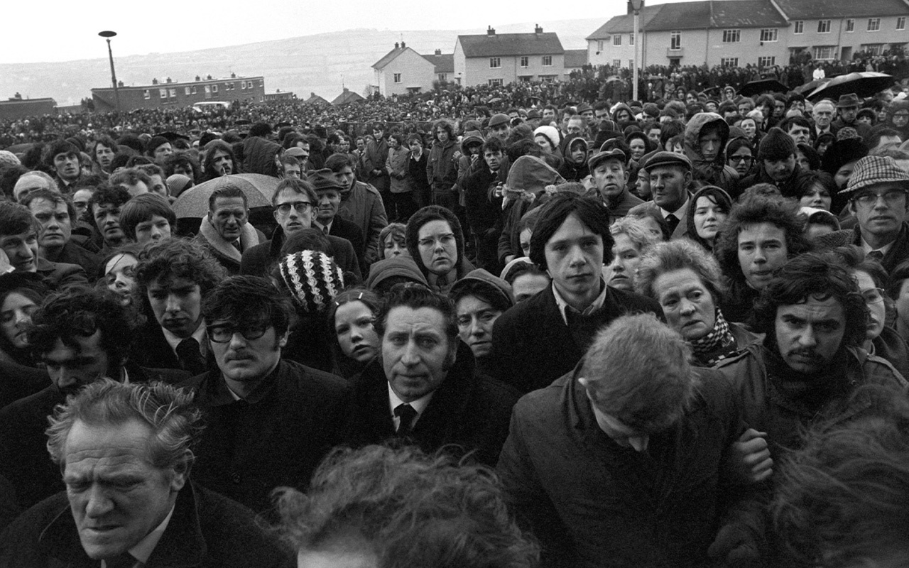 In this image, a silent crowd lines the road to the cemetery in Derry where the 13 protesters who died in a particularly brutal incident known as Bloody Sunday were buried.