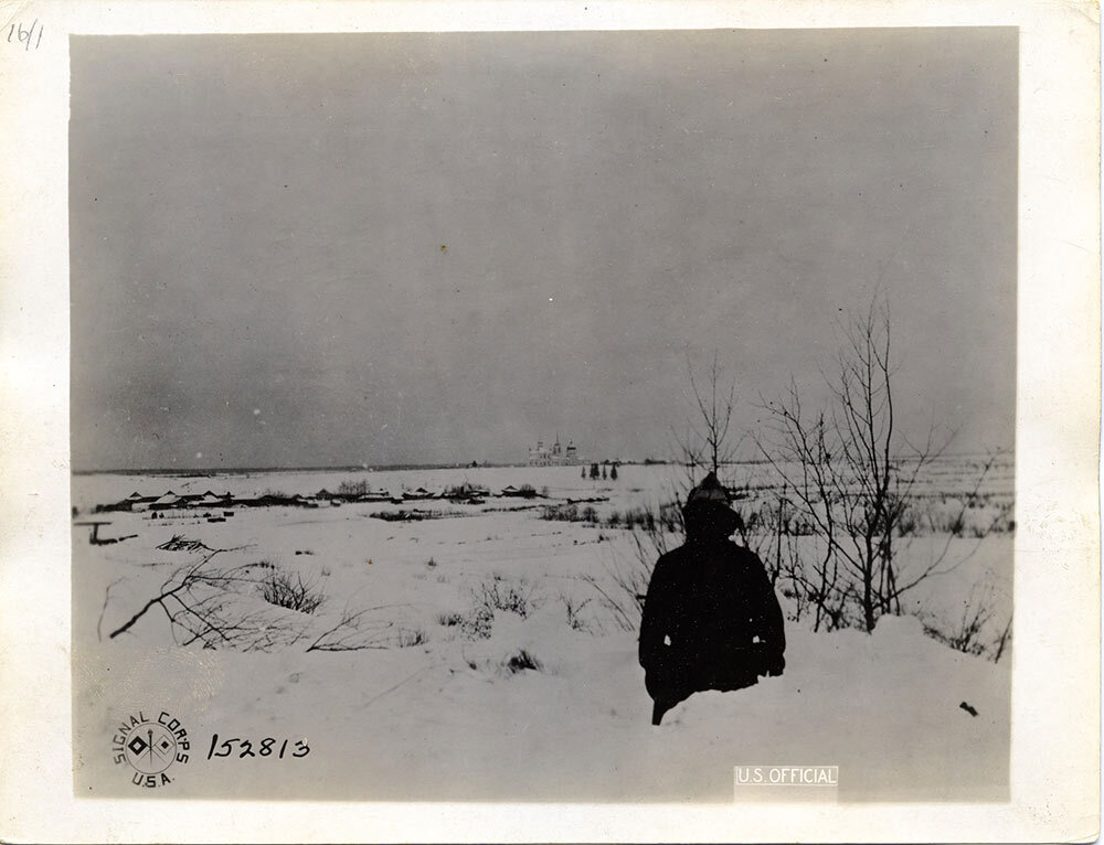 In this photo from January 7, 1919, Private Alfred Schuck of Cicero, Illinois looks across a snowy expanse at a church near Ust Padenga, Russia, used by Bolshevik forces as an observation post and a firing position against U.S. troops.