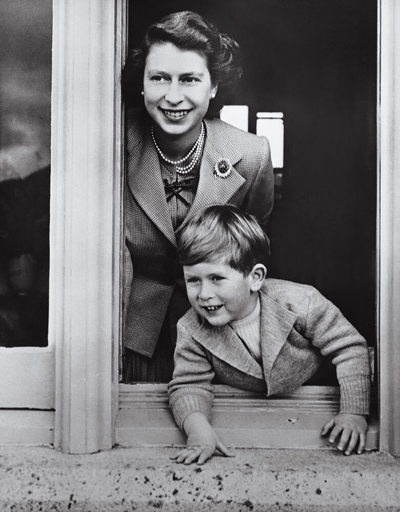 A young Queen Elizabeth and her son look out a window