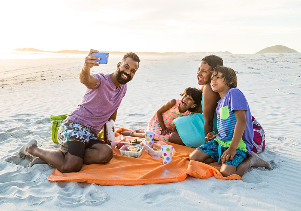 A family taking a selfie on the beach