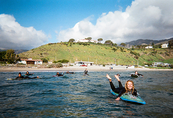 Jordyn Romero paddles out at First Point, a section of ocean closest to the pier with the most consistent waves, in Malibu, California. Surfing is riding a wave of popularity since the pandemic began, with more young people picking up boards.