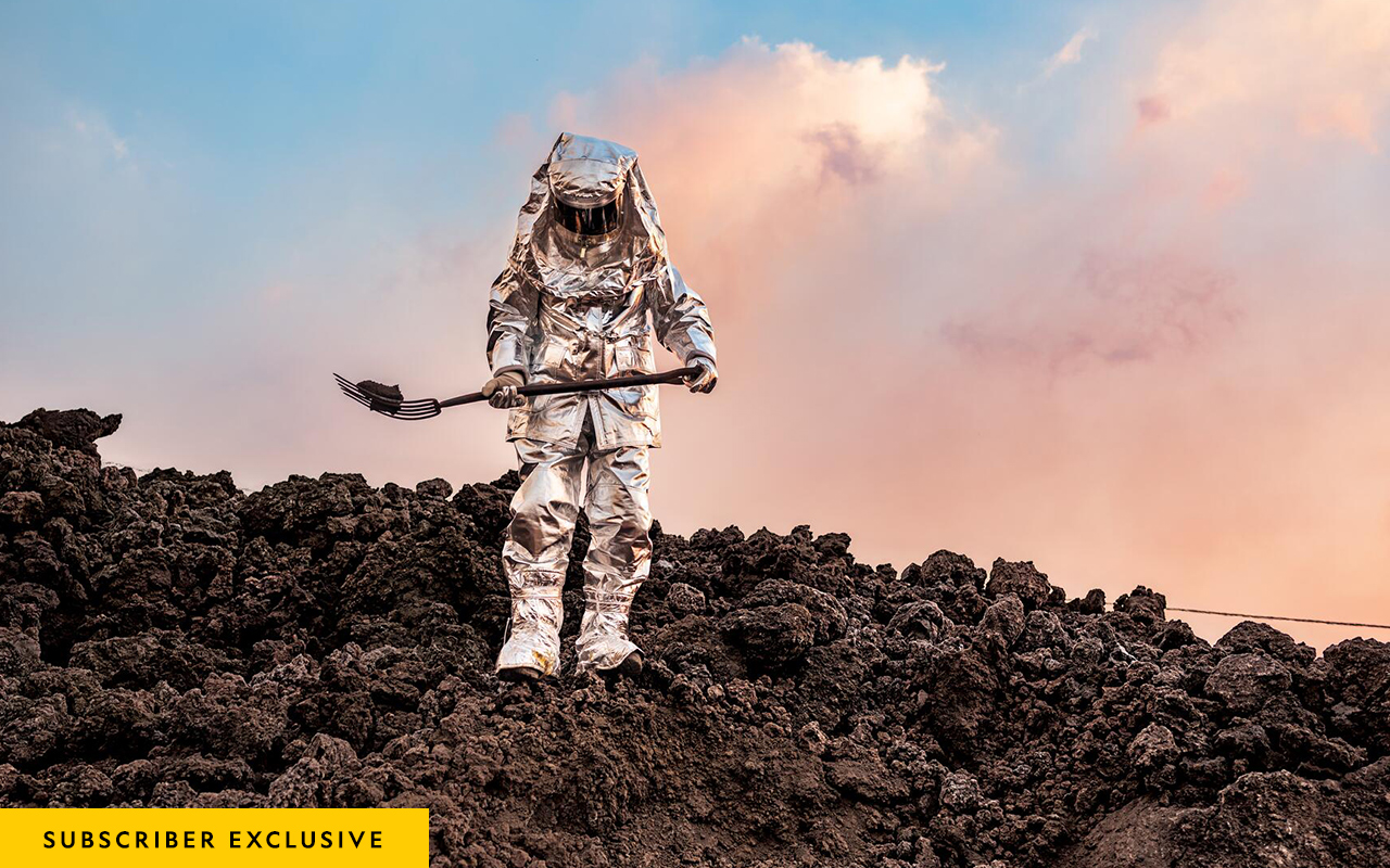 Picture of  person in a protective suit walking on hot rocks and carrying one on a pitchfork.