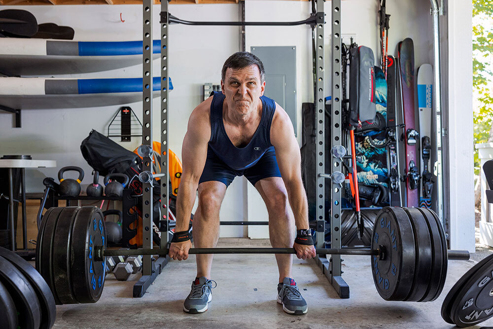 A man lifts weights. Many scientists say the key to preventing disease in old age is getting enough exercise, including weightlifting.
