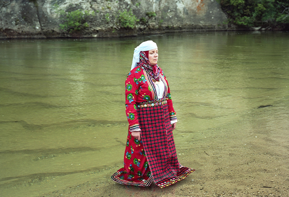 Emine Bourountzi stands at the edge of a river in Greece.