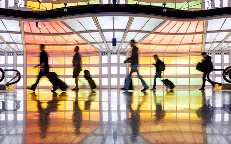 Travelers walk past a neon-light art installation by Michael Hayden in a pedestrian tunnel at Chicago O'Hare International Airport.