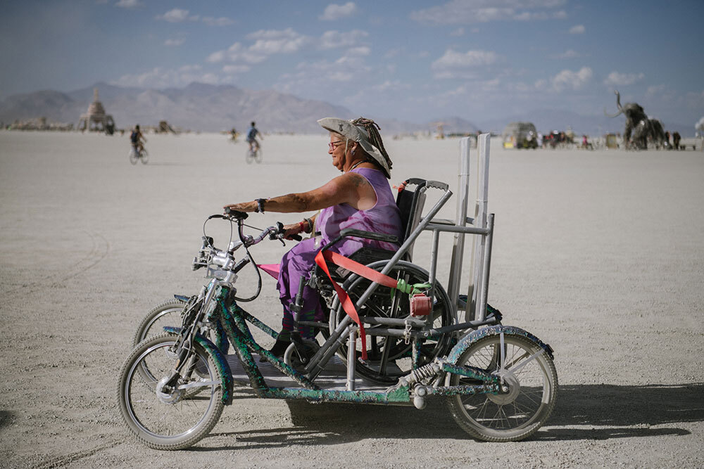 A woman rides a four wheel vehicle while in her wheelchair