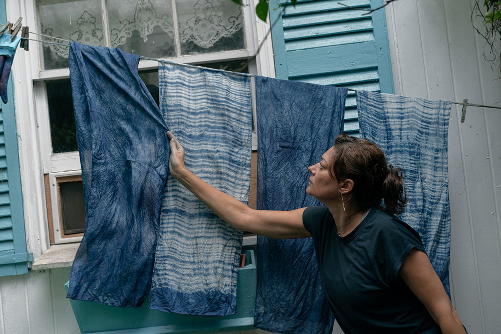 Caroline Harper straightens scarves dyed with indigo