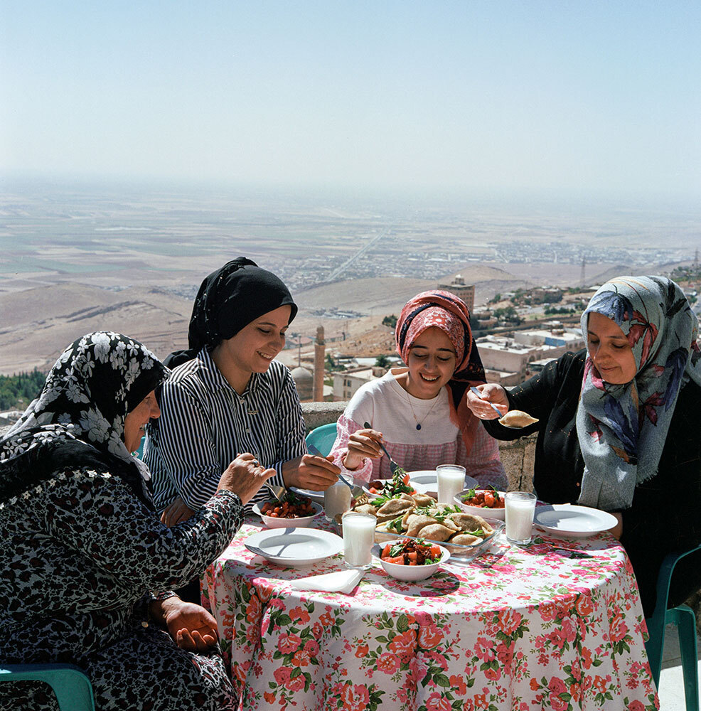 A picture of a family enjoying a meal on an outdoor terrace