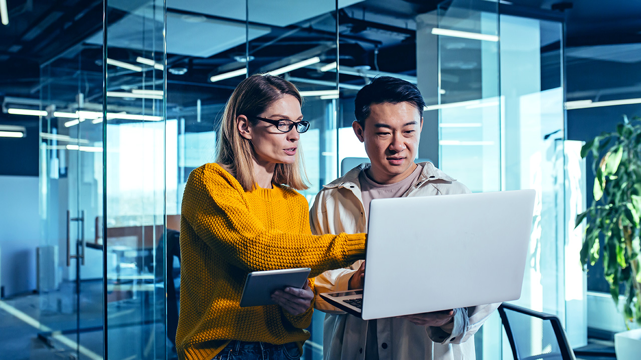 Photo of two people looking at a laptop together.