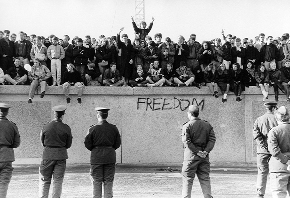 West Germans scale the Berlin Wall before East German guards as the Cold War barrier came down in November 1989.