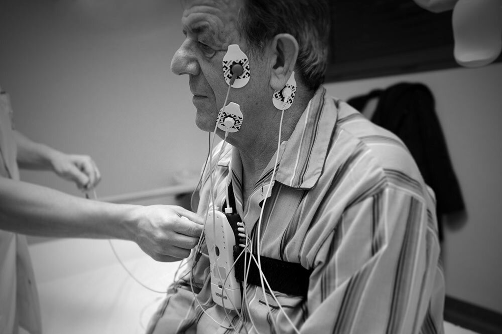 Staff at a sleep clinic in France place monitor leads on a patient in preparation for a polysomnography.