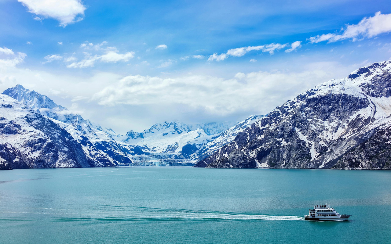 A tour boat cruises past Johns Hopkins Glacier in Alaska’s Glacier Bay National Park and Preserve.