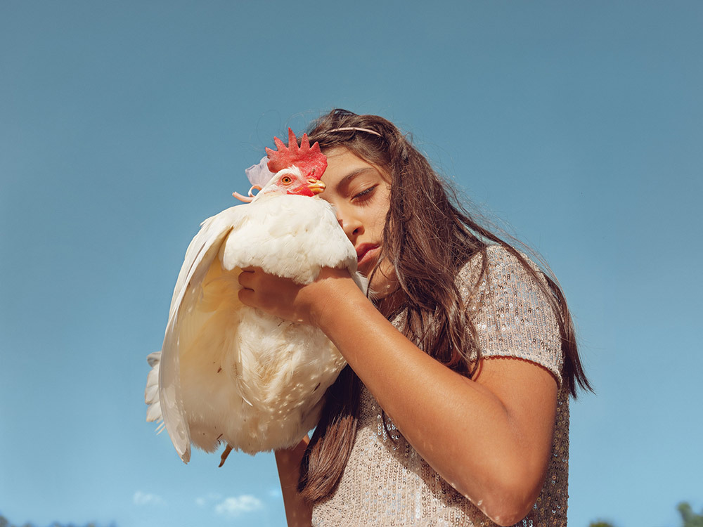 a girl holds a chicken