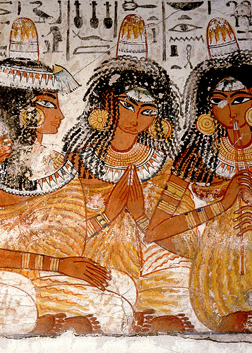 Part of a banquet scene from the tomb of Nebamun, Four young women wearing pleated gowns and wigs with lotus blossoms and unguent cones play music for the banquet guests.