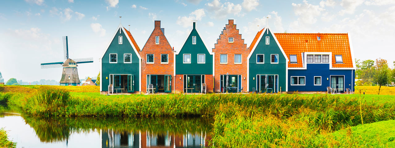 Steep-gabled houses edge the marshes of a marine park in Volendam, North Holland.