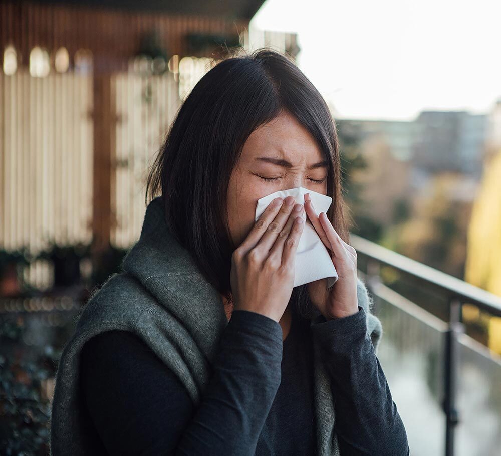 A woman blows her nose