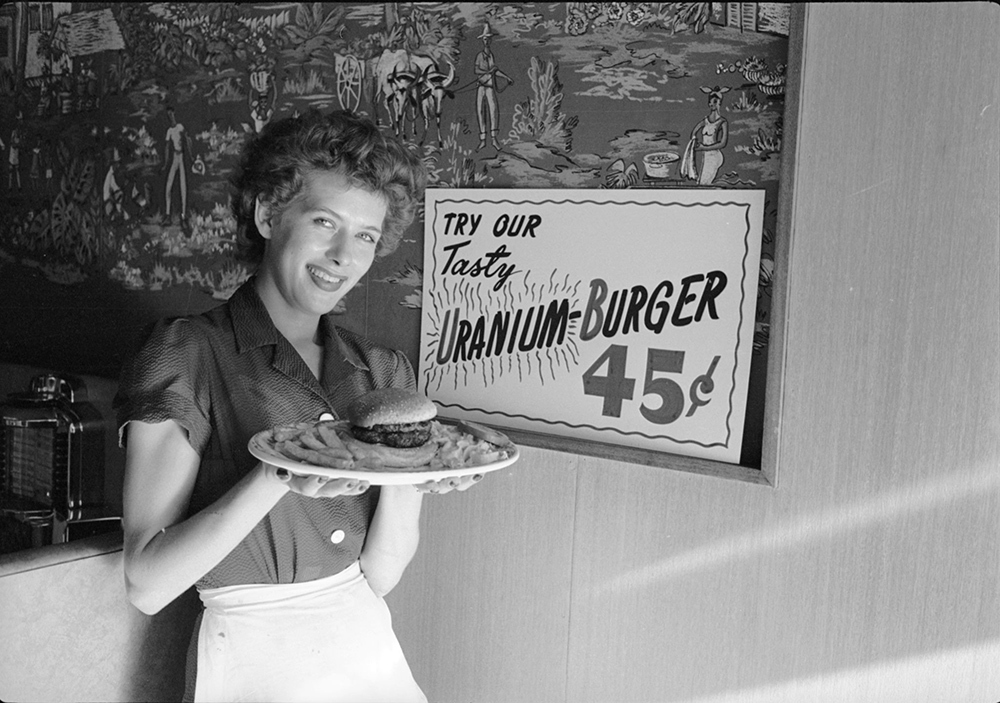 A waitress poses with a 'Uranium-Burger' at a diner, Salt Lake City, Utah, 1954. The sandwich is so named for the region's booming uranium industry