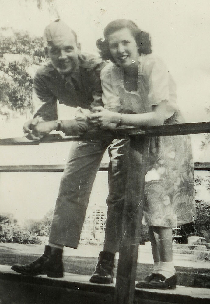 A photograph of a couple standing on a walkway