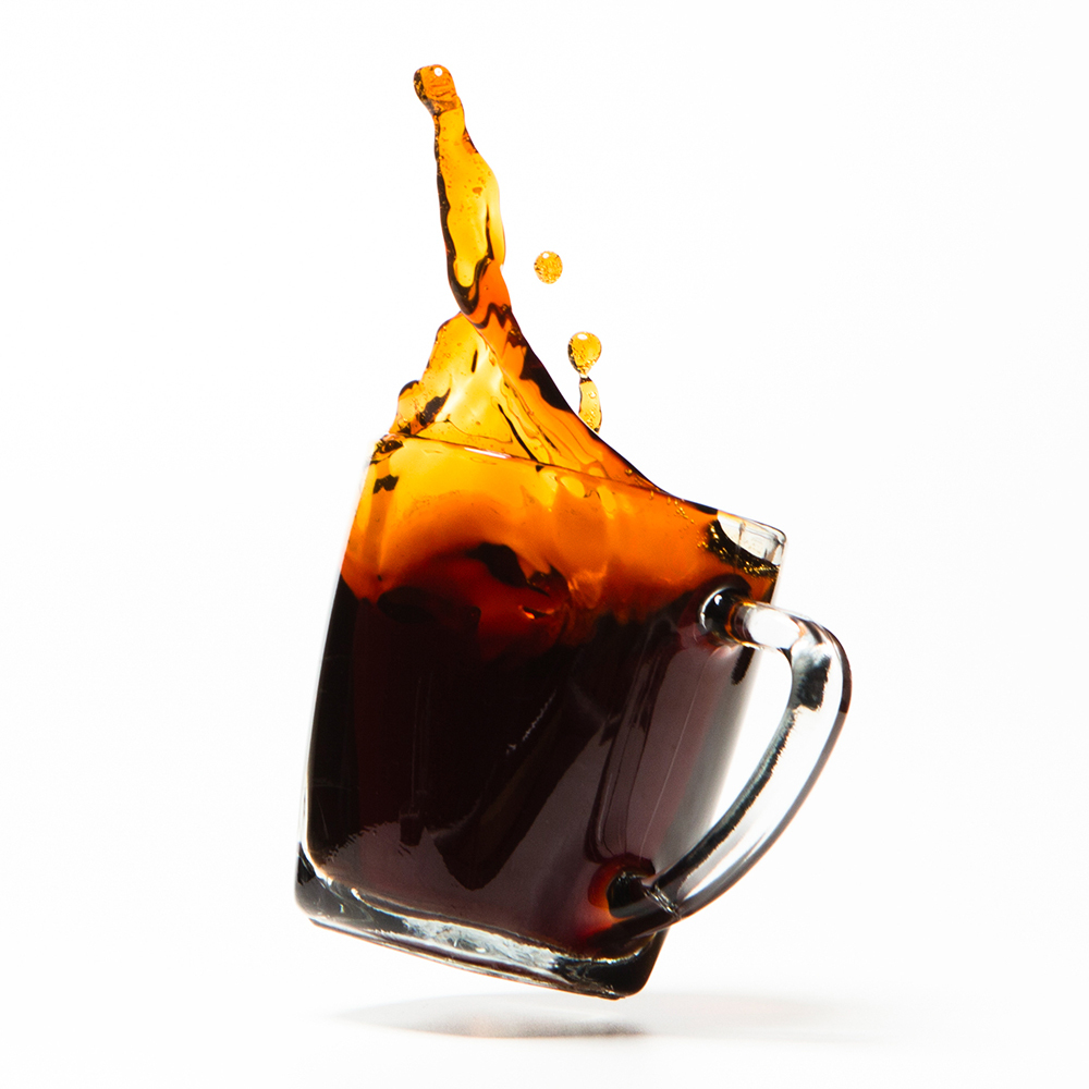 Coffee splashing out of a clear mug