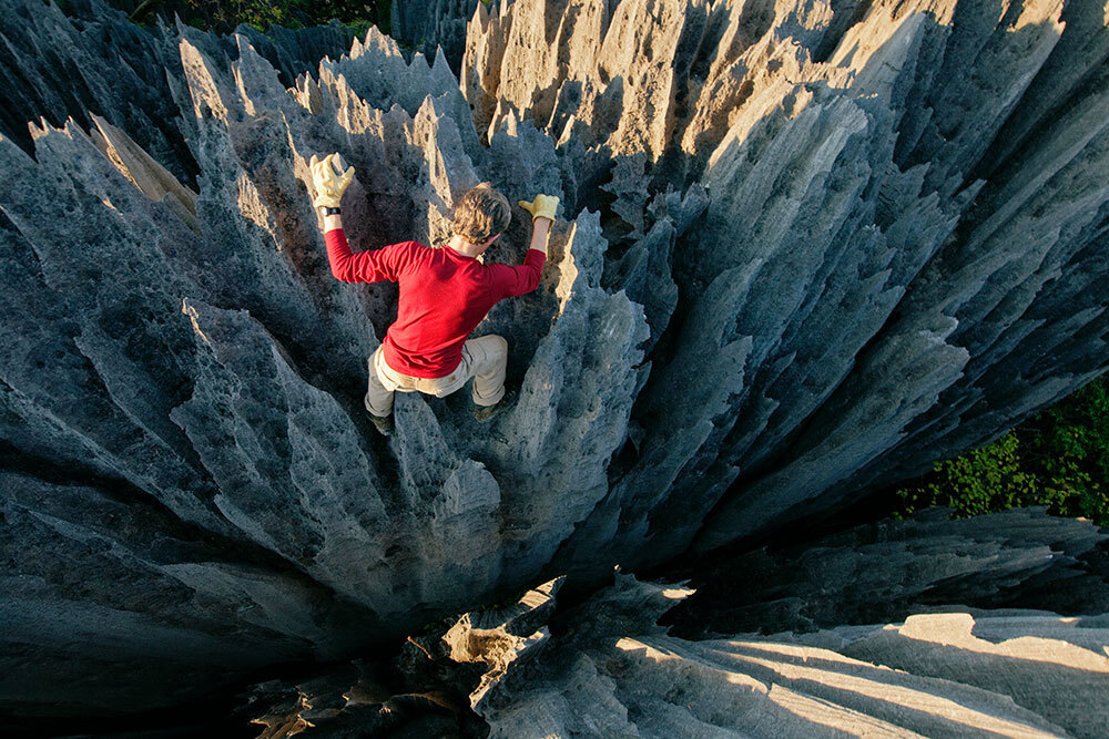 A man climbs jagged spires jutting out of the ground