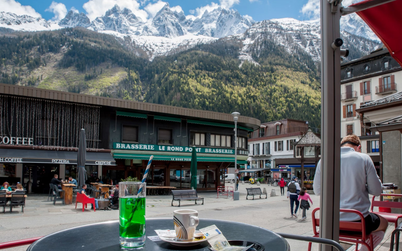 In Chamonix, France, a bright green glass of diabolo sits on a café table.