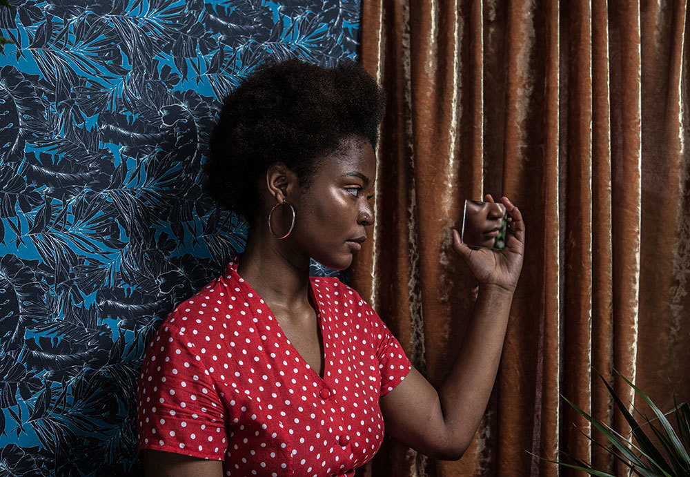 A woman looking in a handheld mirror