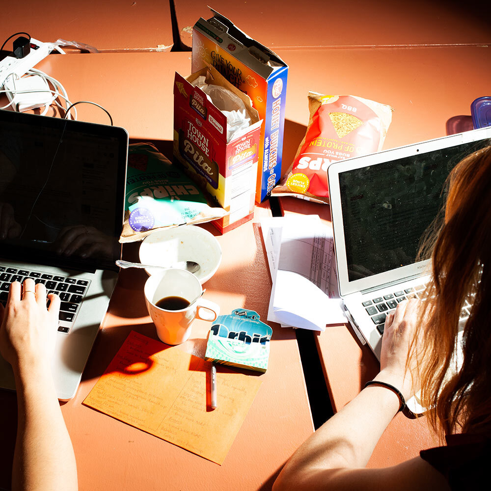 two people eat at their desks