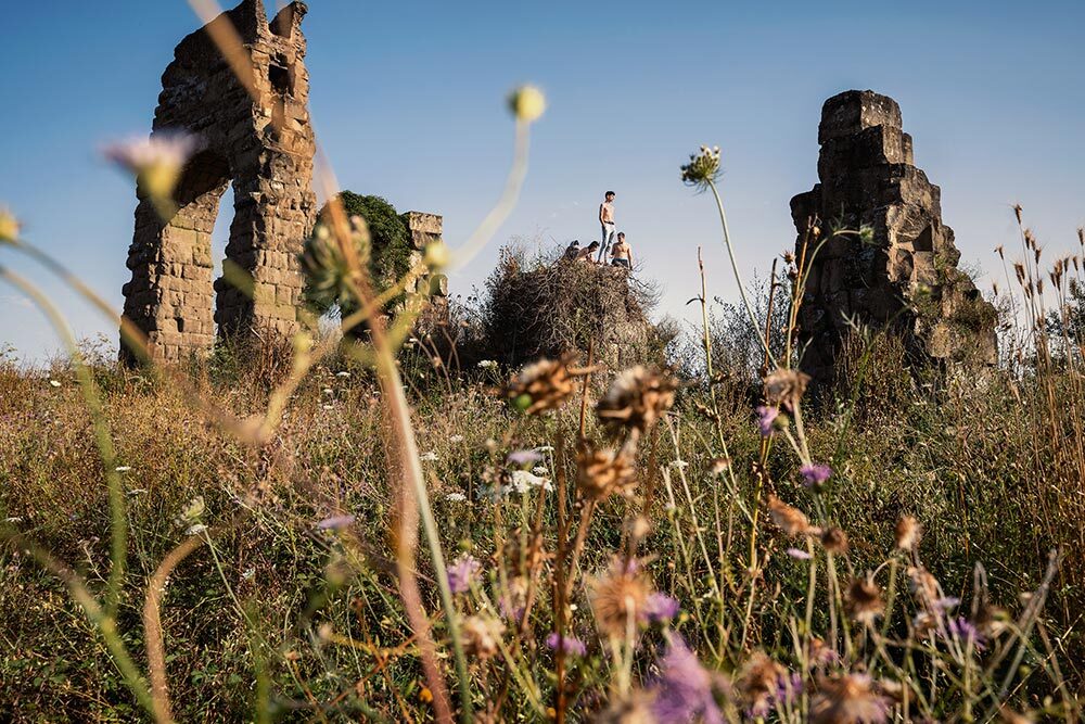 Teenagers in a field of wildflowers among ancient Roman ruins