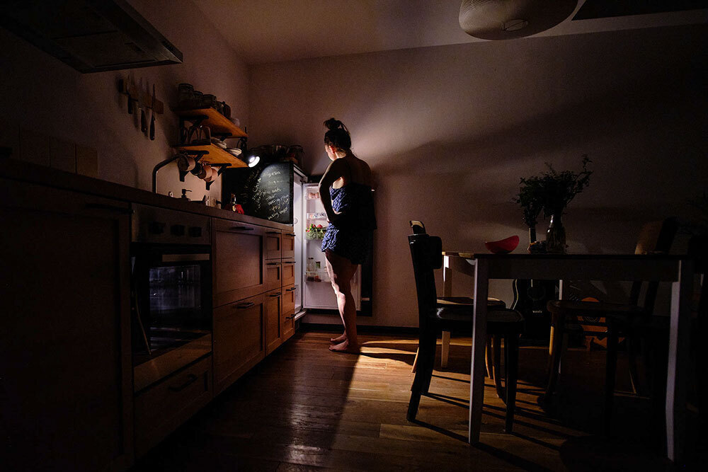 A picture of a person opening a refrigerator