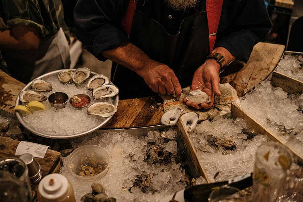 A person cuts and prepares oysters to eat