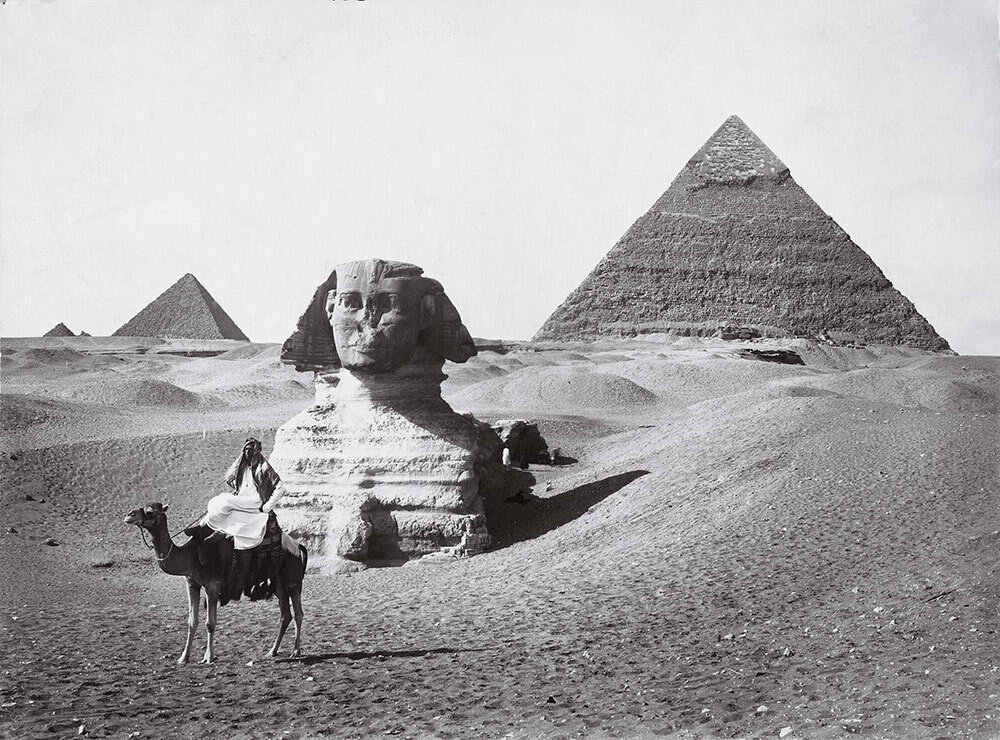 a rider on a camel takes a rest before the Sphinx and the pyramids of Giza, photographed for a 1913 issue of National Geographic