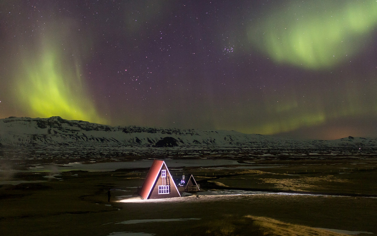 Iceland's distinct architecture, such as this house on the outskirts of Húsavík, adds to the dramatic nighttime setting.