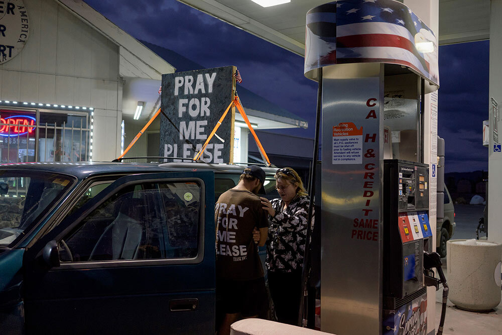 two people praying at a gas station