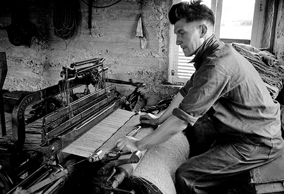 In this 1955 photo, a weaver in the Outer Hebrides is shown producing Harris Tweed on a foot-pedal loom. The centuries-old textile tradition carries on in these remote islands off the west coast of Scotland.