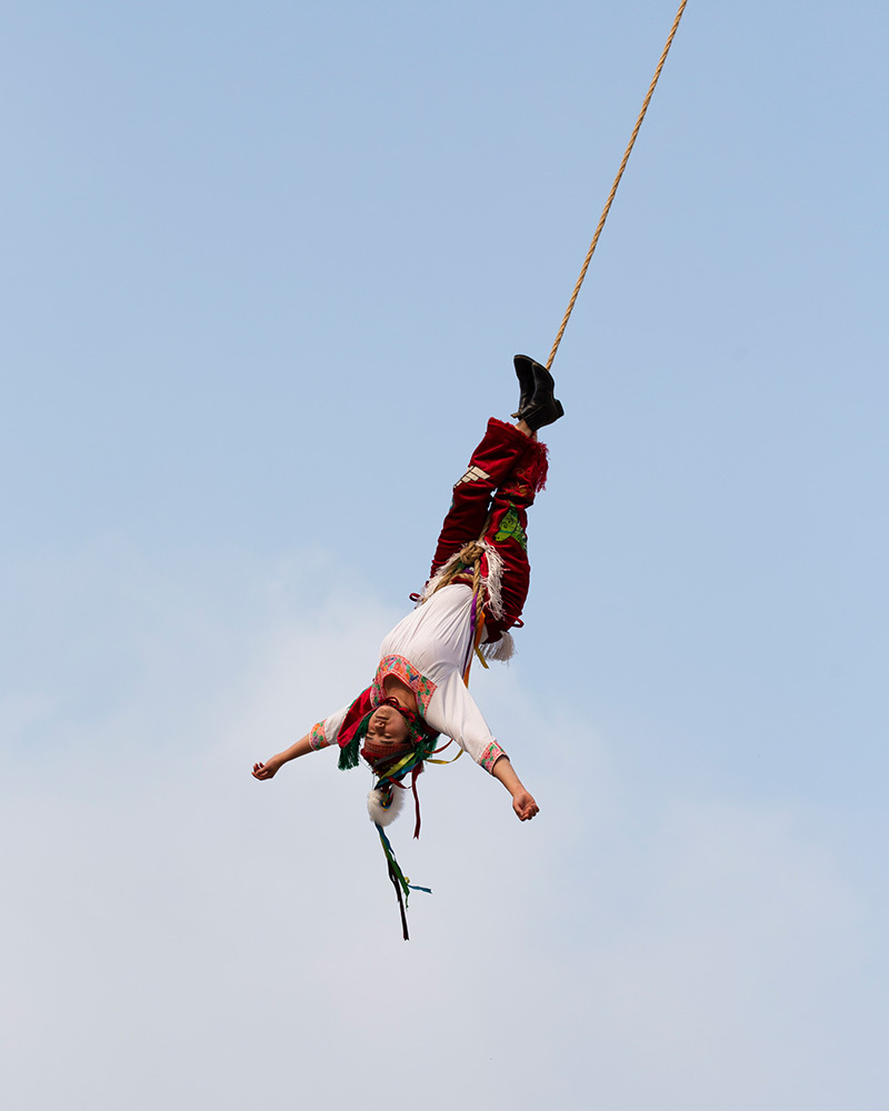 A woman hangs by her feet