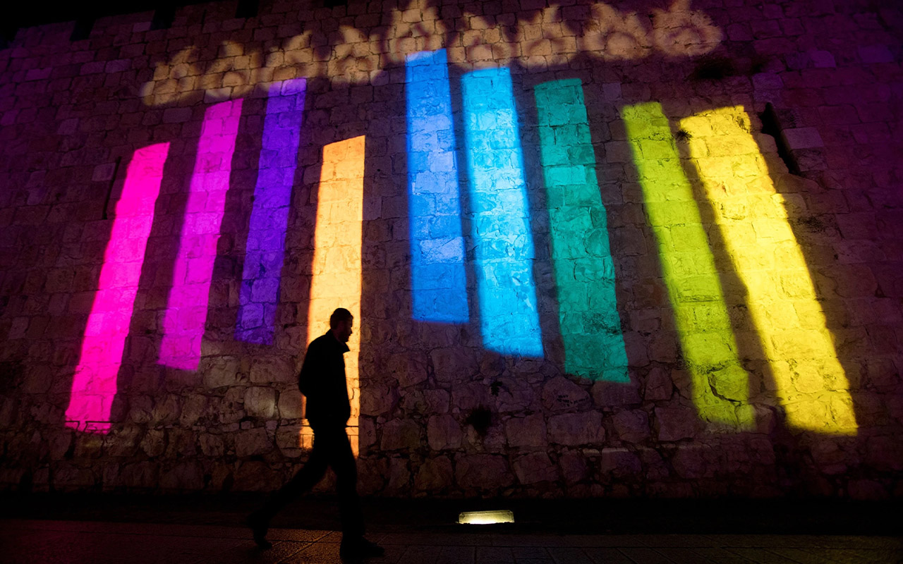 On the walls of Jerusalem's Old City, a colorful menorah lights up the night during Hanukkah.