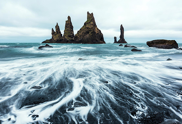 According to Icelandic folklore, the basalt rock formations off the coast of Vik were once trolls.